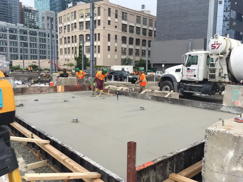 Large poured concrete foundation being finished on a commercial building site
