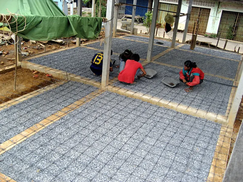 Rebar mesh laid out on a prepared base before a concrete slab foundation is poured